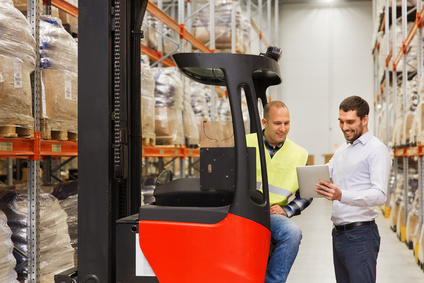 men with tablet pc and forklift at warehouse