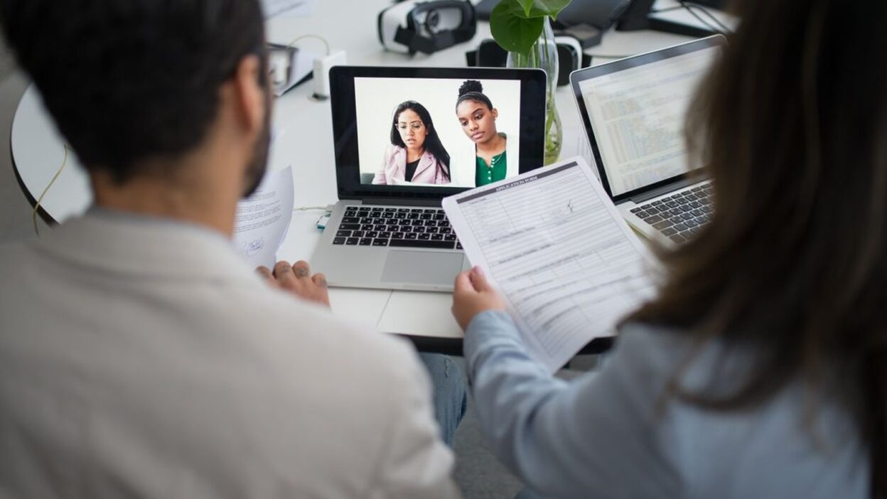 Zwei Personalverantwortliche fuehren ein Online-Bewerbungsgespraech am Laptop