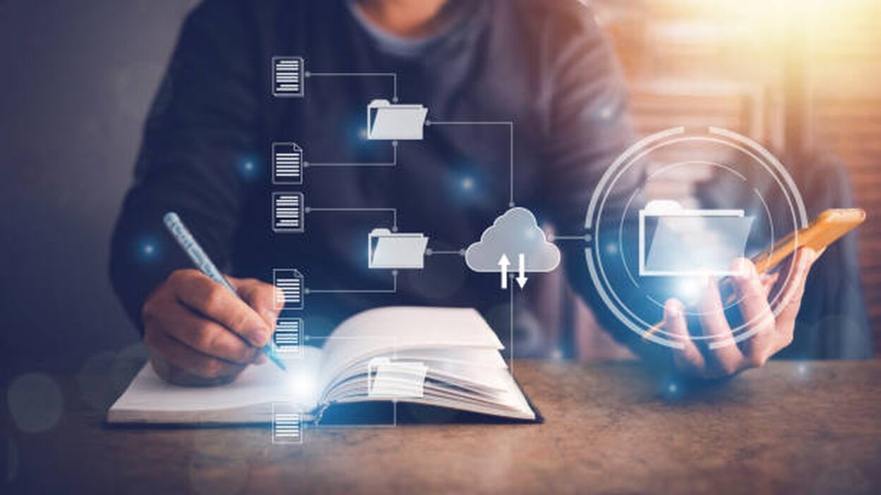 Person schreibt in ein Notizbuch, daneben digitale Ordner- und Cloud-Symbole als Sinnbild für einen digitalen Content-Workflow